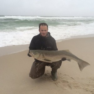 Evan Priovolos with a catch and release striped bass from the surf.